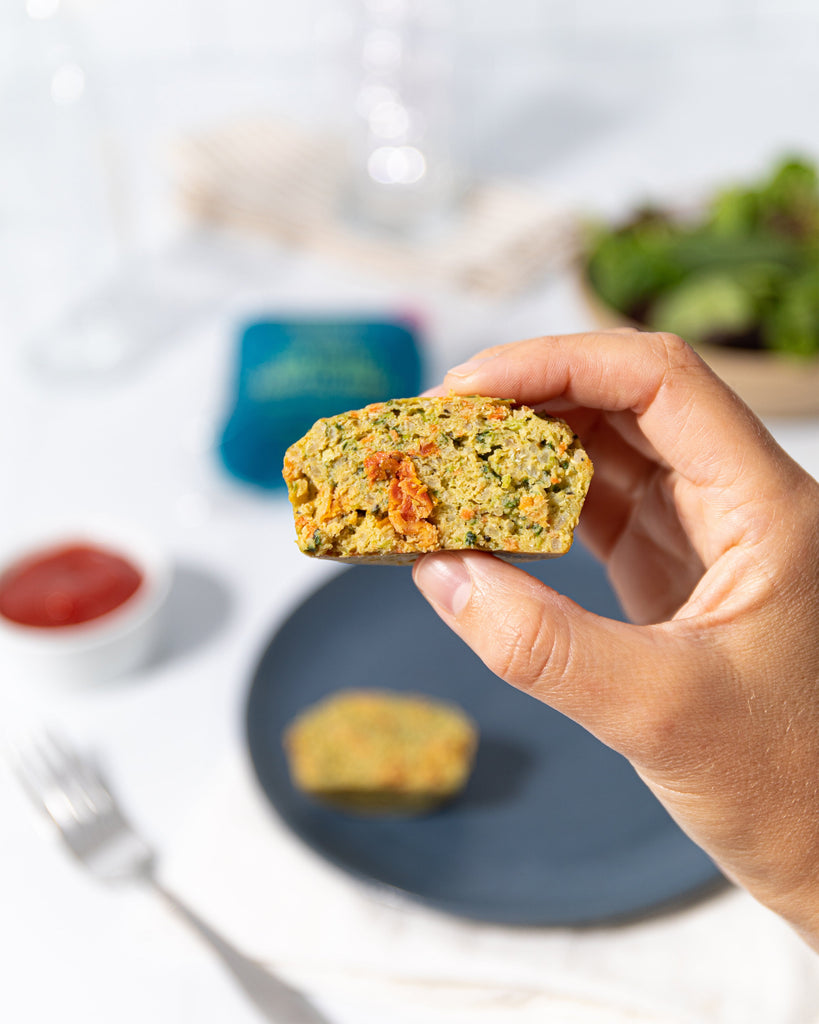 close up hand shot of appletons market Sun dried tomato basil power veggie bite filled with cage free eggs quinoa chickpea flour and healthy veggies for the perfect easy snack or mini meal with fiber and protein 